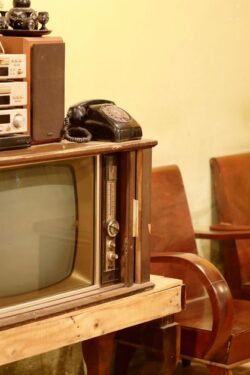 A nostalgic old-school living room with a vintage TV, stereo, and rotary phone reminiscent of the era before 1980.