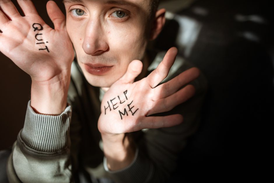 A man reaching out with "Help Me" written on his palm, symbolizing the importance of asking for help before things fall apart.