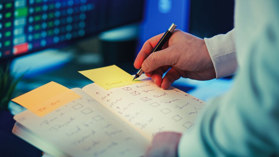 A person checking off items on a to-do list, embracing the idea that done is better than perfect.