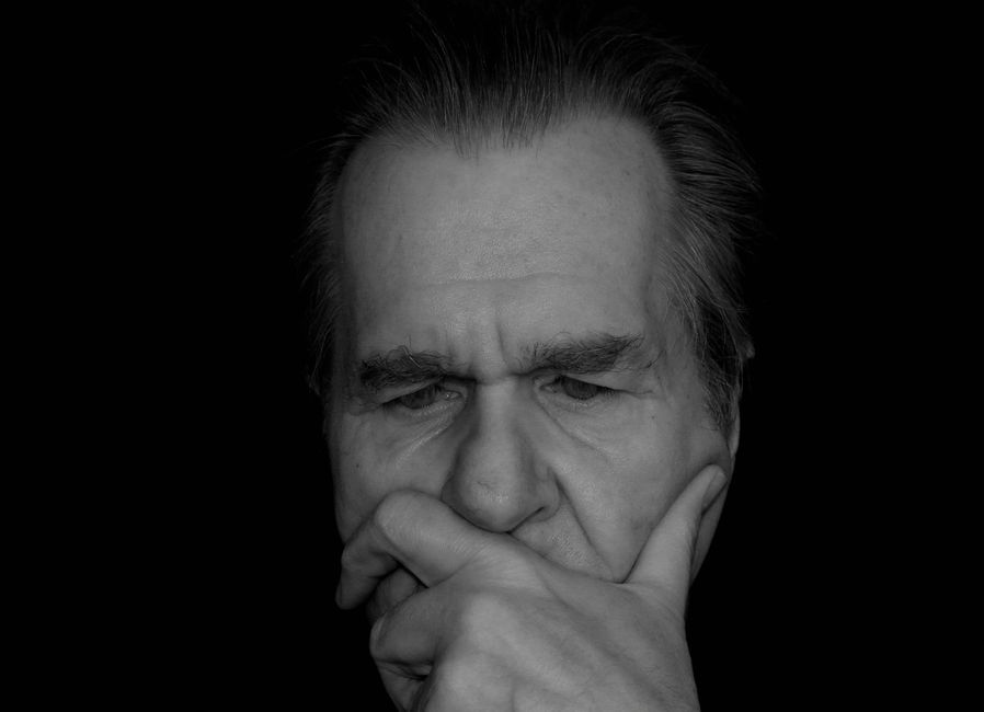 An older man deep in thought, reflecting on something serious and heavy to think about.