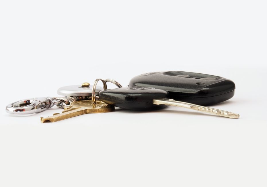 A cluttered keyring with old keys and a fob, the kind worth sorting through to remove ones that no longer open anything.