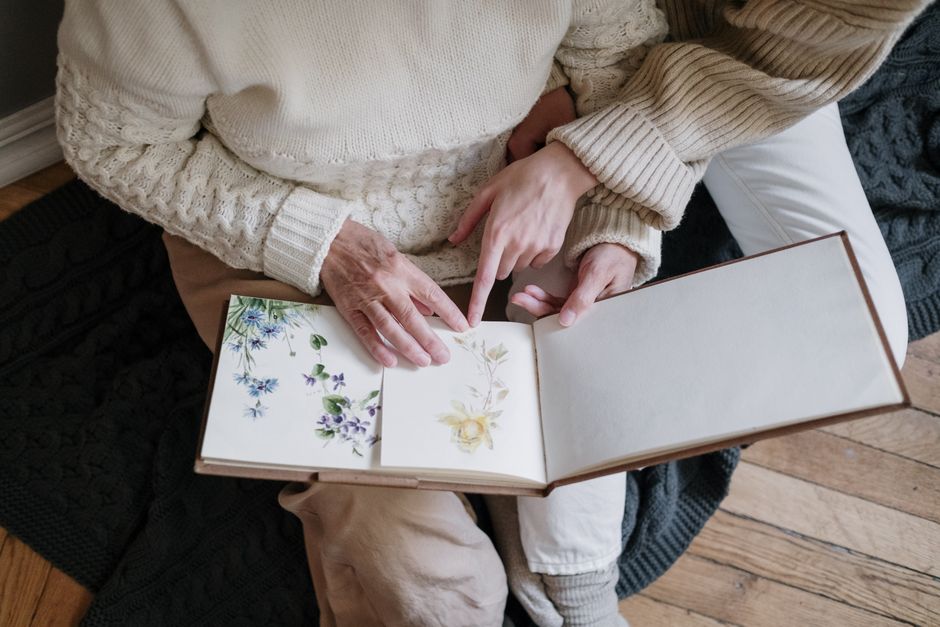 A mother and daughter looking through an old photo album together, perhaps reminiscing about childhood memories.