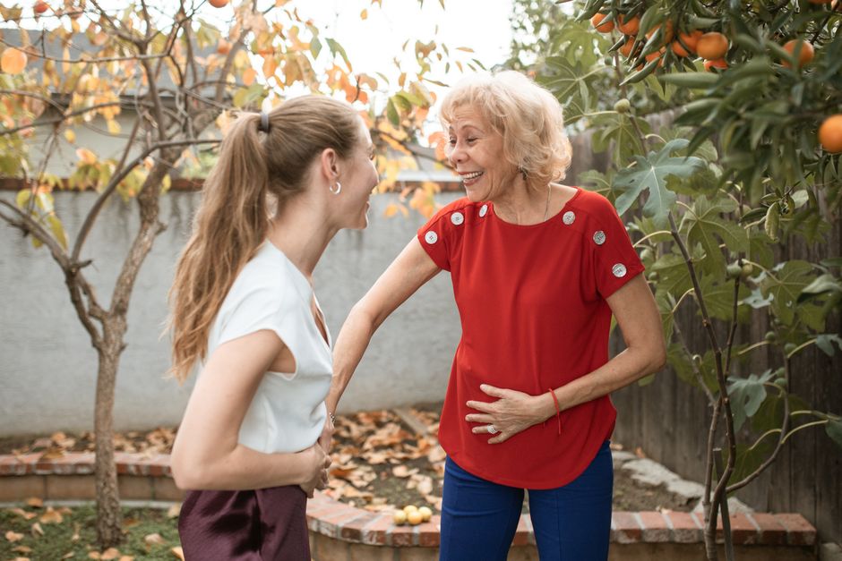 A mother and daughter sharing a joyful conversation outdoors, a perfect moment to ask what she is most proud of.