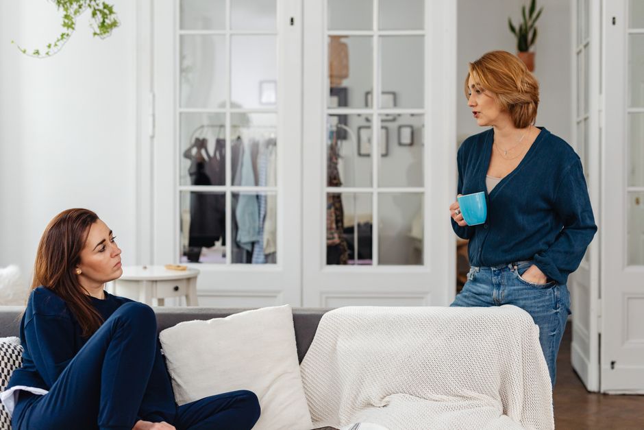 A mother and daughter sit together in quiet, thoughtful conversation, sharing a heartfelt moment of reflection.