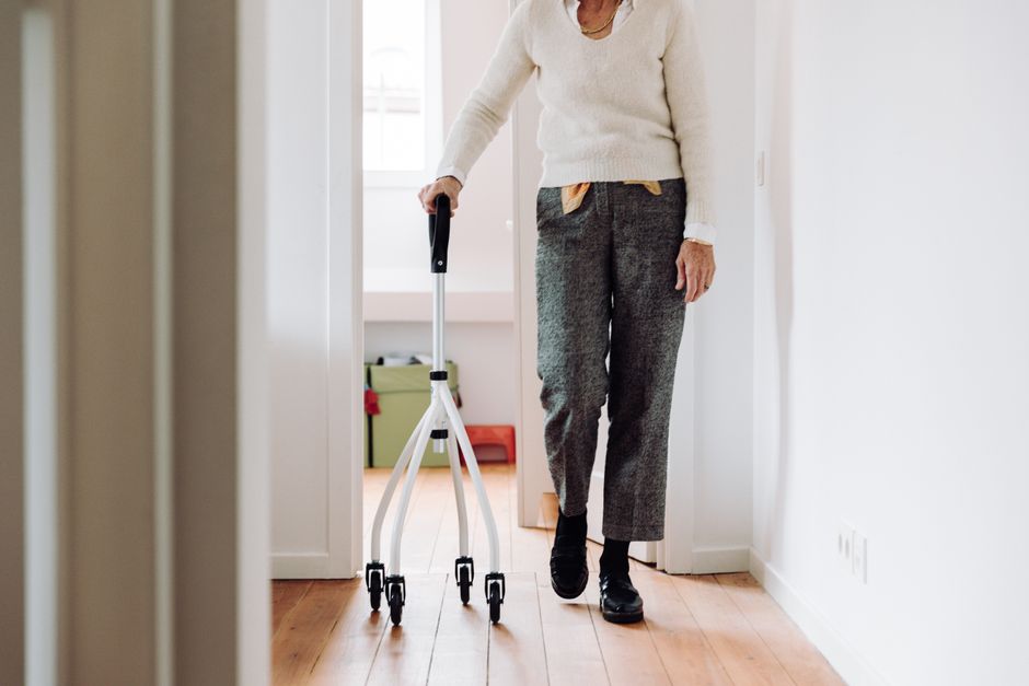 An elderly person walking confidently in comfortable shoes with the help of a walker, embracing self-care in their golden years.