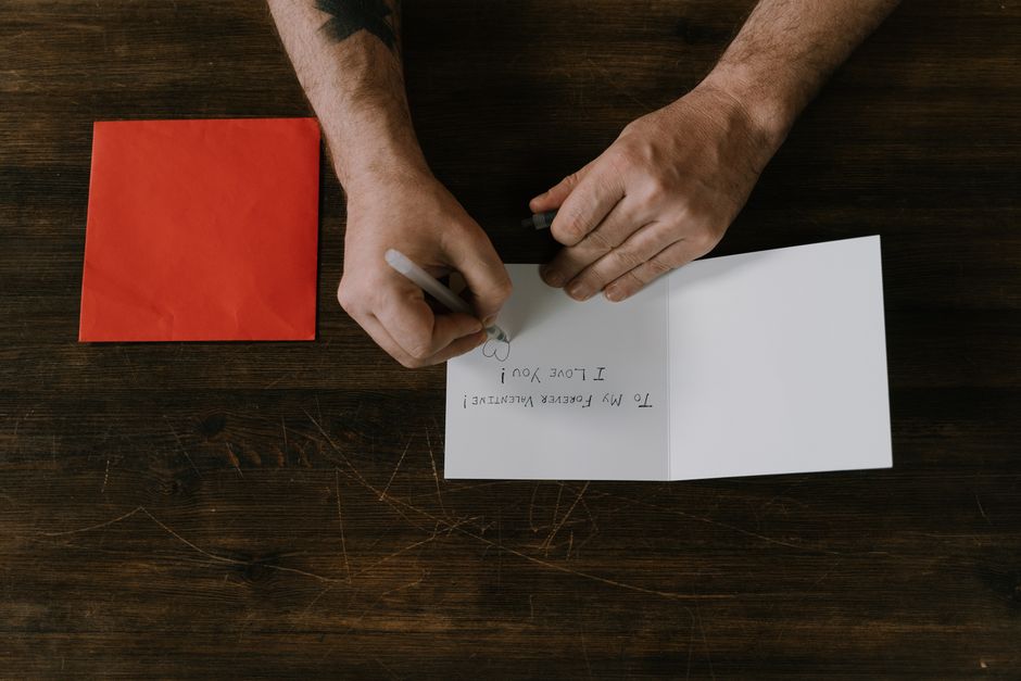 Hands writing a heartfelt handwritten card, a small gesture that still carries real meaning.