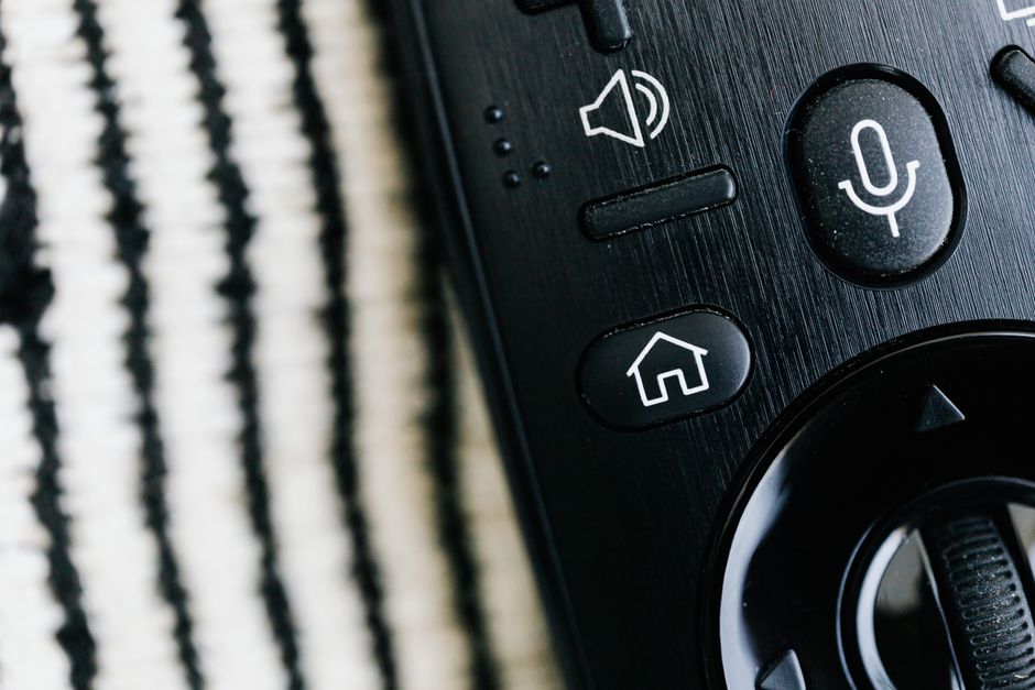 Close-up of a remote control's volume button, representing the habit of turning the volume down to protect hearing.