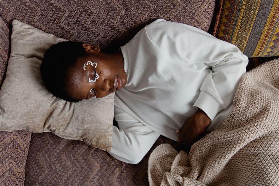 A person peacefully resting on a couch, embracing rest as an essential part of life's journey.