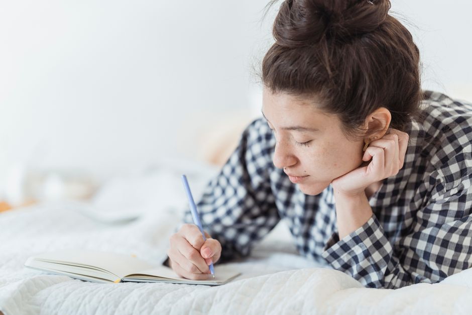 A woman jotting down life wisdom in her journal so she won't forget it.