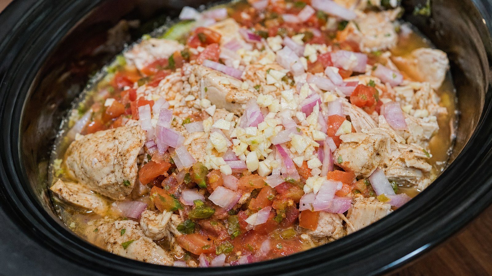 Slow Cooker Chicken Tacos: Scatter the onion and garlic over the chicken. Pour the salsa and broth on top and add the juice of 1 lime. St
