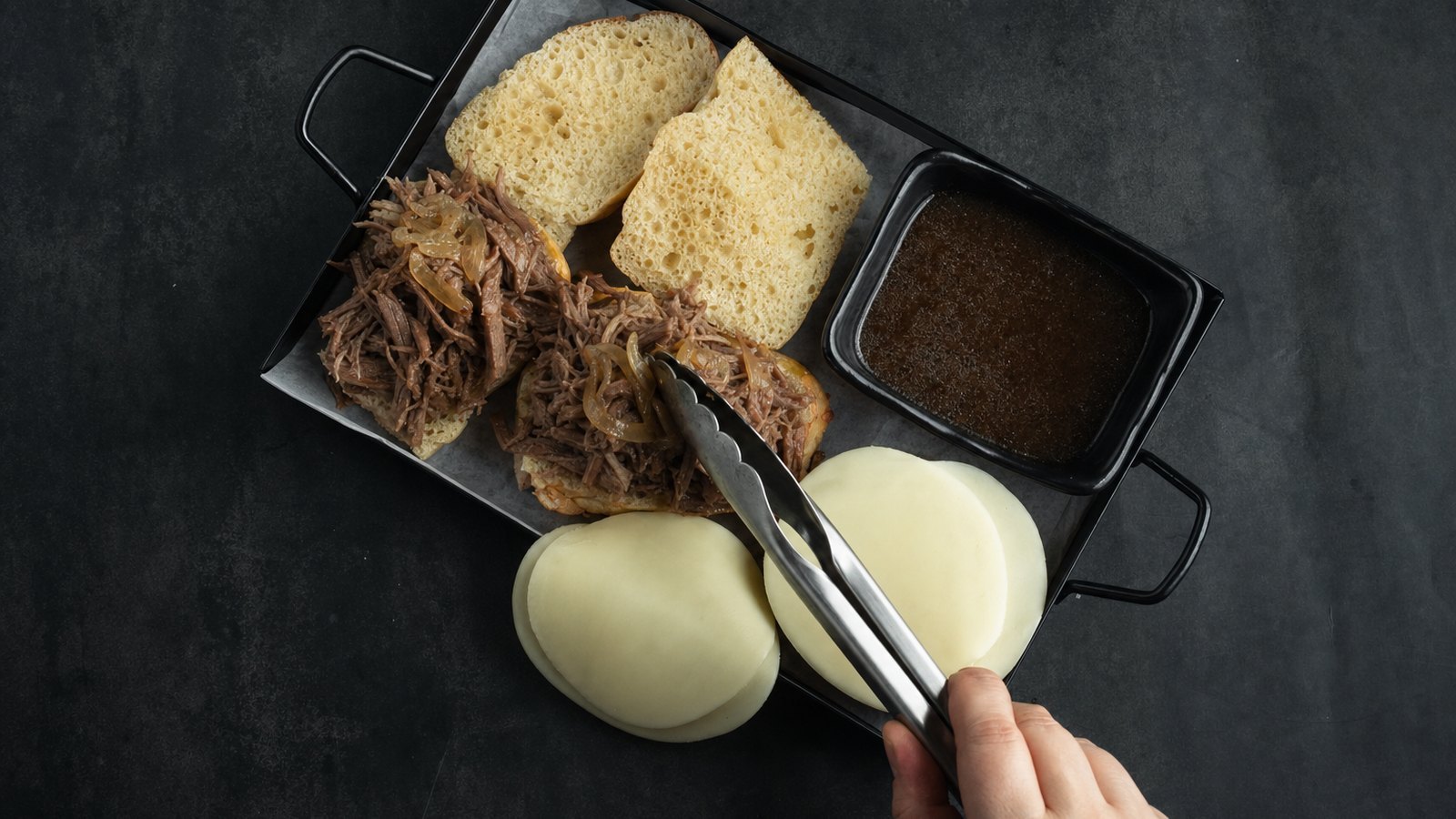 Slow Cooker French Dip Sandwiches: Using tongs, pile shredded beef onto the bottom halves, letting excess liquid drip off. Add some of the cooked