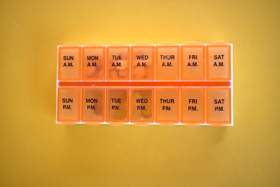 A weekly pill organizer representing the power of small, consistent daily habits over grand plans.