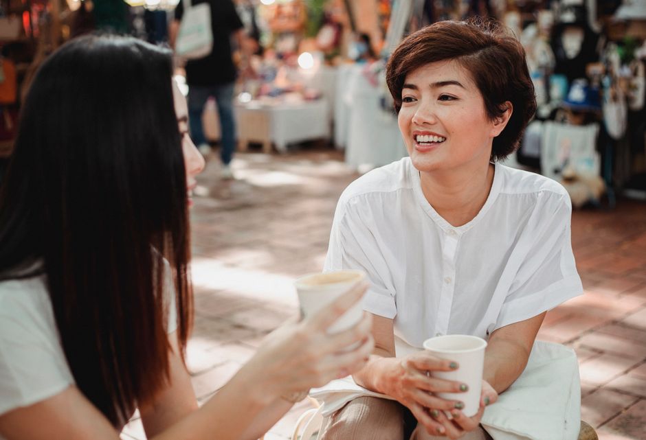 Two friends sharing a warm smile and kind words over coffee