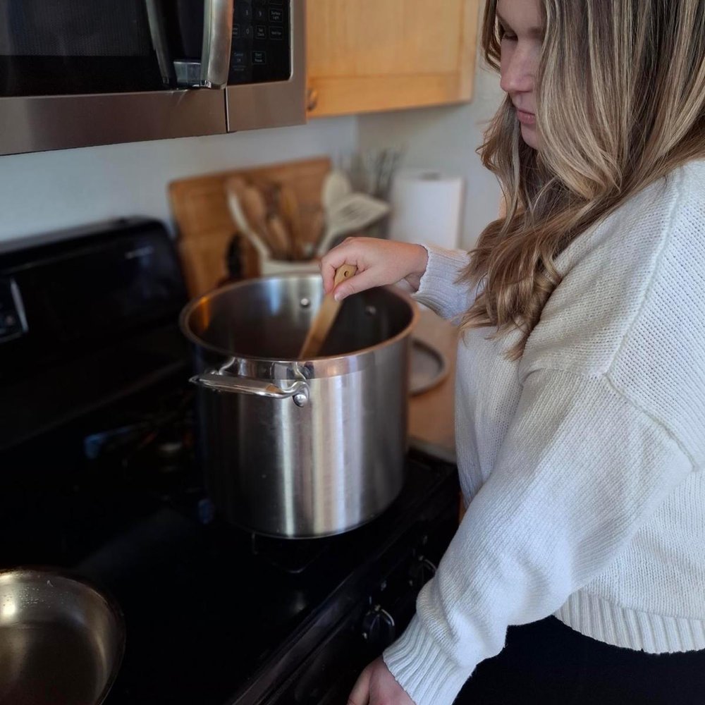 Isabel stirring a pot of soup on the stove