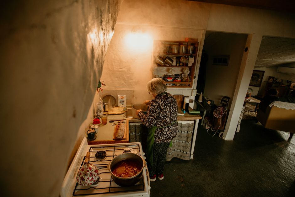 A woman quietly cooks a simple meal at the stove, skipping the pressure of trying a fancy new recipe for guests.