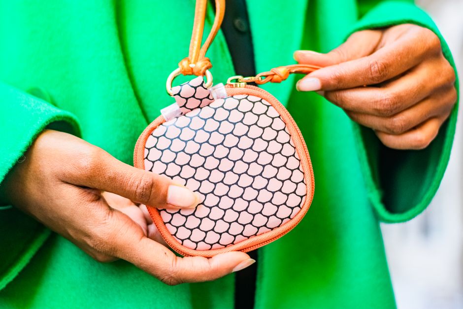 A small patterned zip pouch held in hand, perfect for containing kids' small treasures in a purse.